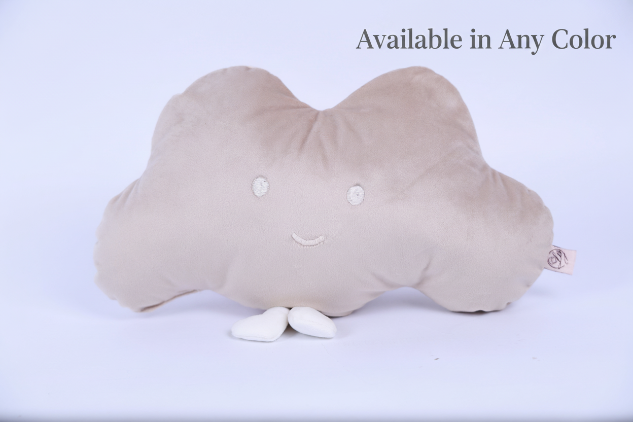 Cloud-shaped pillow with a smiley face on a white background