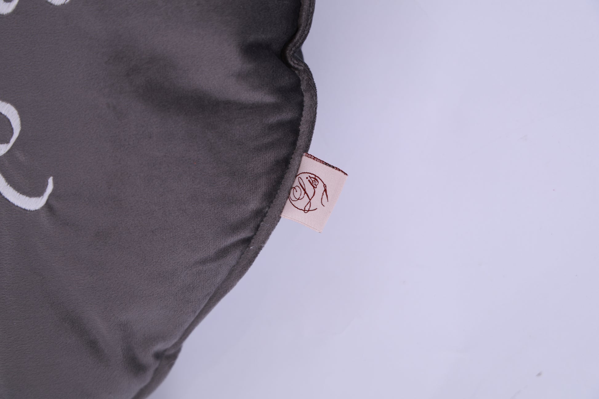 Gray pillow with a brand tag on a light gray background