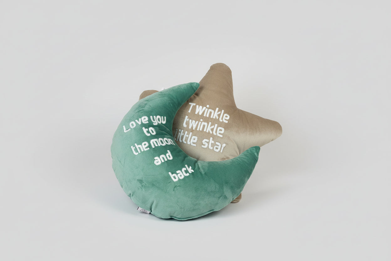 Two decorative pillows with nursery rhymes on a wicker chair.