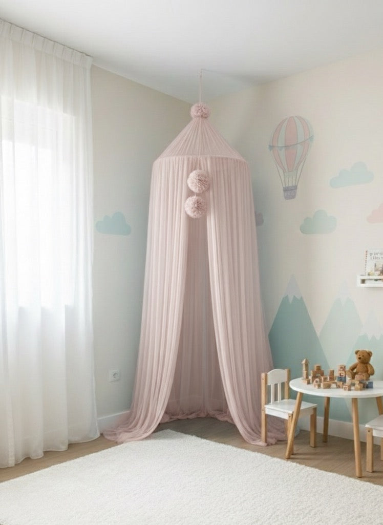 Pink canopy in a child's room with toys and furniture.